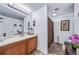 Neutral toned bathroom with a wood vanity, large mirror, and separated toilet and shower stall at 10787 Twenty Mile Rd # 205, Parker, CO 80134