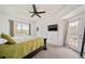 Bright bedroom with ceiling fan, tan carpet, double french doors, and a large window at 10787 Twenty Mile Rd # 205, Parker, CO 80134