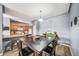Open concept dining room features wood-look floors, modern lighting, gray walls, and a glimpse into the kitchen at 10787 Twenty Mile Rd # 205, Parker, CO 80134