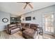Cozy living room featuring a ceiling fan, wood-look floors, light gray walls, and a comfortable leather sectional at 10787 Twenty Mile Rd # 205, Parker, CO 80134