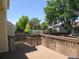 A wooden back deck offers a view of a green, fenced in yard in a neighborhood setting at 19421 E Evans Dr, Aurora, CO 80013