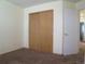 This bedroom features neutral walls, brown carpet, and a closet with sliding wooden doors at 19421 E Evans Dr, Aurora, CO 80013
