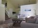 Bright living room boasts neutral tones, a vaulted ceiling, and access to the upper level at 19421 E Evans Dr, Aurora, CO 80013