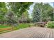 Expansive backyard featuring a wooden deck, patio area, and mature trees at 10883 Otis Cir, Westminster, CO 80020