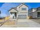 Two-story house with gray siding, attached garage, and landscaping at 17771 E 93Rd Ave, Commerce City, CO 80022