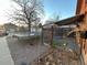 Spacious backyard featuring a trampoline, gravel area, and a fenced dog run with a shaded shelter at 2602 Jasmine St, Denver, CO 80207