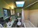 Cozy bathroom features a sink, toilet, bathtub, shower with vintage charm and a bright skylight at 2602 Jasmine St, Denver, CO 80207