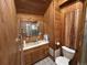 Bathroom featuring wooden walls, with a well-lit vanity area and a shower with a glass door at 2602 Jasmine St, Denver, CO 80207