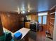 Compact kitchen featuring wood paneled walls and stainless steel appliances at 2602 Jasmine St, Denver, CO 80207