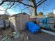 Backyard shed with a blue tarp, a bicycle and a metal fence at 2602 Jasmine St, Denver, CO 80207