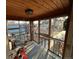 Bright sunroom featuring wood paneled walls, many windows and a view of the yard at 2602 Jasmine St, Denver, CO 80207