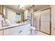 Bright bathroom featuring a marble countertop vanity, white cabinets, and a glass-enclosed shower at 5432 S Dayton Ct, Greenwood Village, CO 80111