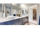 Bathroom with double sink vanity, large mirror, and walk-in closet at 5432 S Dayton Ct, Greenwood Village, CO 80111