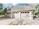 Three-car garage with white doors, gray roofing, and a spacious driveway at 5432 S Dayton Ct, Greenwood Village, CO 80111