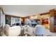 Cozy living room with a stone fireplace, wood paneling, and seamless view into the nearby kitchen area at 5432 S Dayton Ct, Greenwood Village, CO 80111