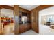 Elegant wet bar featuring custom wood cabinetry, dark countertops, and glass shelving for sophisticated entertaining at 5432 S Dayton Ct, Greenwood Village, CO 80111