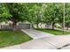 Exterior shot of home with lush green lawn, mature trees and gray two-car garage at 1633 S Trenton St, Denver, CO 80231