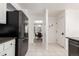 Clean kitchen with tile floors, and access to the dining room, with a modern black refrigerator at 1633 S Trenton St, Denver, CO 80231