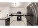 Bright kitchen featuring modern black stainless-steel appliances, white cabinets, and dark countertops at 1633 S Trenton St, Denver, CO 80231