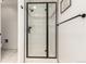 Modern shower with black trim glass doors, updated fixtures, and white subway tile surround at 1633 S Trenton St, Denver, CO 80231