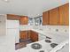 Functional kitchen with oak cabinetry, white appliances, laminate countertops and a window with natural light at 2323 S Jamaica St, Aurora, CO 80014