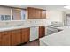 Well-lit kitchen featuring oak cabinets, marble-look countertops, white appliances, and a bright window view at 2323 S Jamaica St, Aurora, CO 80014