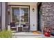 Inviting front porch features stone accents, a cozy seating area, and a welcoming entrance at 19733 W 93Rd Ln # A, Arvada, CO 80007