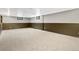 Spacious carpeted basement with two-tone walls and two small windows at 5503 W Colorado Ave, Lakewood, CO 80232