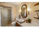 Bathroom with walk-in shower, patterned wallpaper, and decorative vanity mirror at 5503 W Colorado Ave, Lakewood, CO 80232