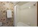 Tiled bathroom with a shower-tub combination and decorative floral wallpaper at 5503 W Colorado Ave, Lakewood, CO 80232