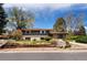 A well-maintained split-level home with mature trees and landscaping creating great curb appeal at 5503 W Colorado Ave, Lakewood, CO 80232