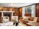 Inviting living room features a brick fireplace, leather sofa, and cozy armchairs at 5503 W Colorado Ave, Lakewood, CO 80232