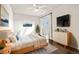 Bright bedroom with hardwood floors, a comfy bed, dresser, and natural light streaming through the window at 1440 Eversole Dr, Broomfield, CO 80023