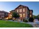 Charming home featuring a stone and stucco exterior, a lush lawn, a stone patio with a fire pit, and mature trees at 1440 Eversole Dr, Broomfield, CO 80023