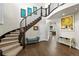 An elegant foyer featuring a curved staircase, hardwood floors, and stylish decor at 1440 Eversole Dr, Broomfield, CO 80023