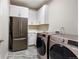 Well-equipped laundry room with a modern washer and dryer set, white cabinets, and countertop space for folding at 1440 Eversole Dr, Broomfield, CO 80023