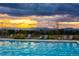 Beautiful pool with lounge chairs set against a backdrop of a colorful sunset and distant mountains at 1440 Eversole Dr, Broomfield, CO 80023