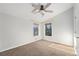 Bright bedroom with a ceiling fan and two windows with views of the trees outside at 7892 Beverly Blvd, Castle Pines, CO 80108