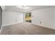 Finished basement space with neutral carpeting and a sliding glass door to the outside at 7892 Beverly Blvd, Castle Pines, CO 80108