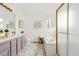 Bright bathroom features lavender vanity, shower and soaking tub at 1261 E 135Th Pl, Thornton, CO 80241
