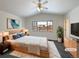 Virtually staged main bedroom with wood floors and large window at 445 Tumbleweed Dr, Brighton, CO 80601