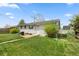 The back yard features a brick patio, lush lawn, mature trees, and a full wooden fence at 8012 Zuni St, Denver, CO 80221