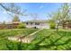Spacious backyard with a lush lawn and mature trees at 8012 Zuni St, Denver, CO 80221