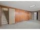 Basement with paneling, tile floors, stairs, and a doorway at 8012 Zuni St, Denver, CO 80221