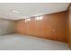 Unfinished basement featuring wood-paneled walls and small windows at 8012 Zuni St, Denver, CO 80221