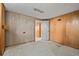 Unfinished basement with an open doorway and wood paneled walls at 8012 Zuni St, Denver, CO 80221