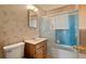 Cozy bathroom featuring a toilet, vanity, shower and tub combination, and patterned wallpaper at 8012 Zuni St, Denver, CO 80221