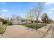 Exterior view of a charming home with a manicured lawn, concrete driveway, and shade trees at 8012 Zuni St, Denver, CO 80221