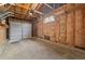 Unfinished garage showing a large garage door, exposed studs, and concrete floor at 8012 Zuni St, Denver, CO 80221
