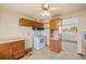 A view of the kitchen features wood cabinets and white appliances at 8012 Zuni St, Denver, CO 80221
